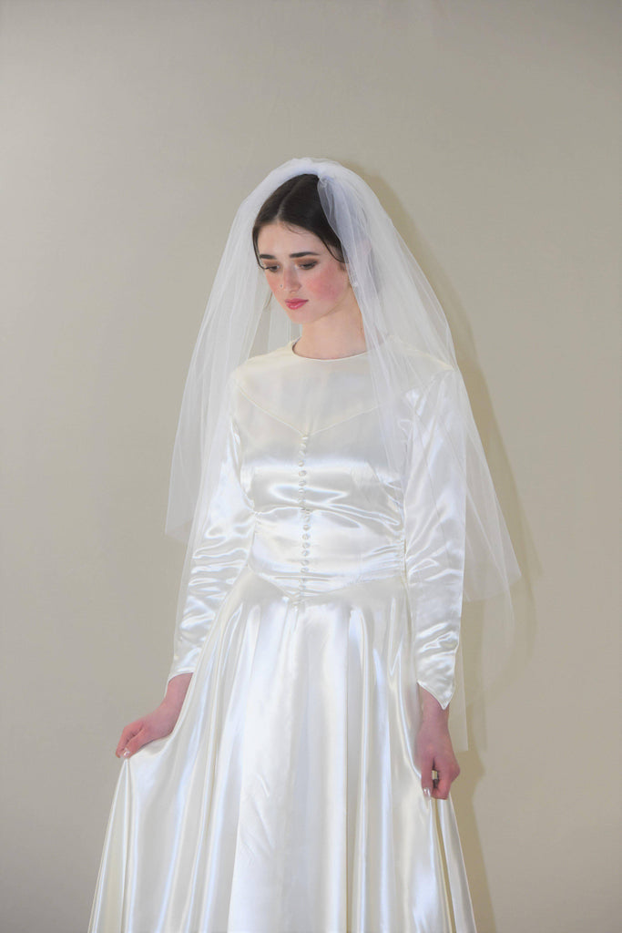 https://cdn.shopify.com/s/files/1/1367/2565/products/Classic-Two-Tier-Fingertip-Veil-with-Blusher_06505538-5131-4cb7-a955-8f0a156cf36d_1024x1024.jpg?v=1658934207