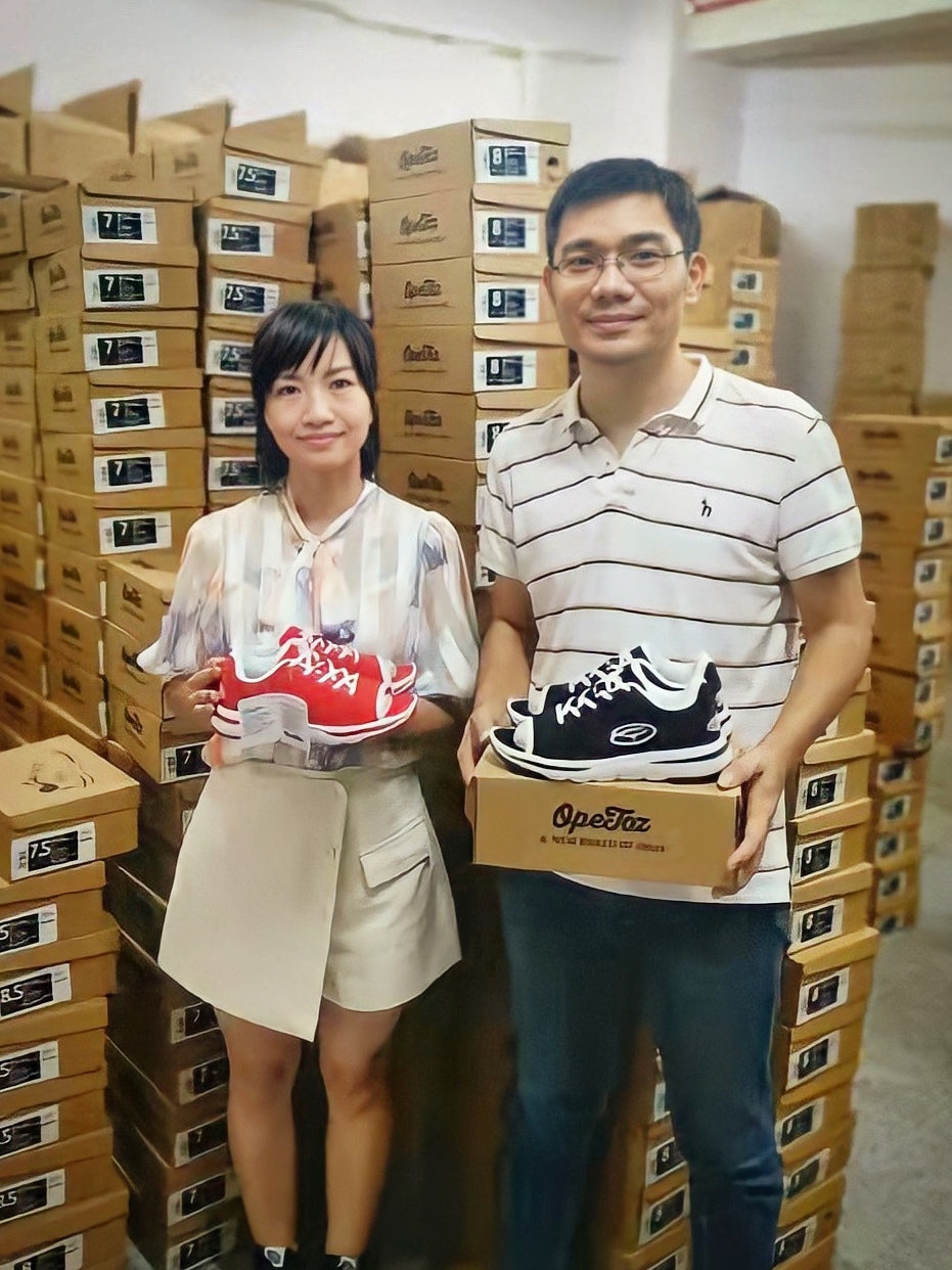 Image of Vincent and Jane each holding an OpeToz Athletic Shoe in the factory where they are being manufactured