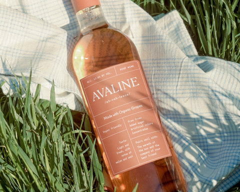 Avaline Rosé laying on a cloth on the grass