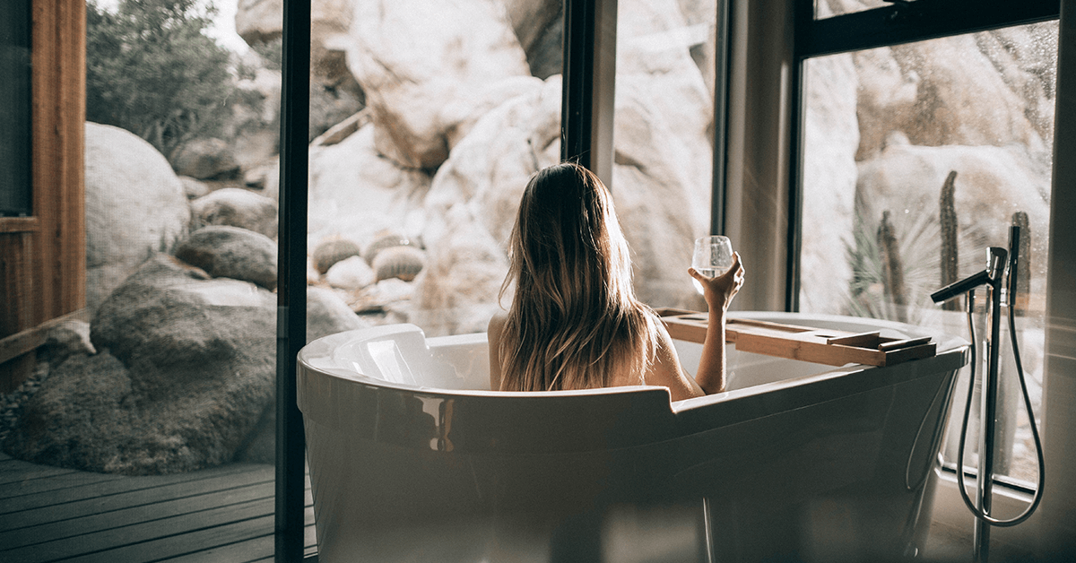 Lady sitting in bath looking at white rock scenery