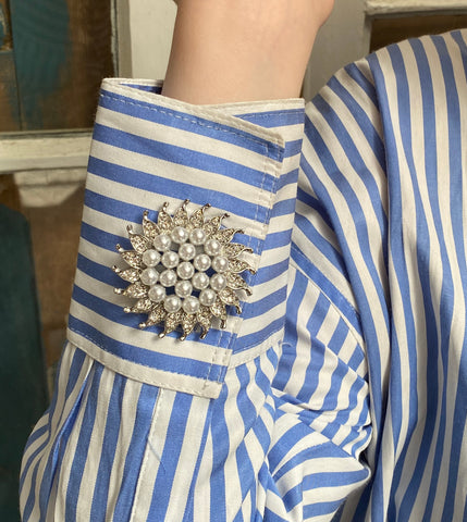 silver pearl and crystal brooch of the cuff of a shirt