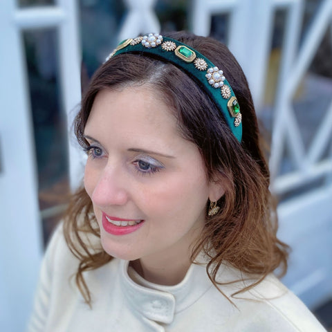 woman wearing green velvet pearl headband smiling and looking off into the distance