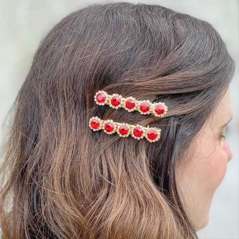 Woman wearing 2 sparkly red hair slides on one side of her hair