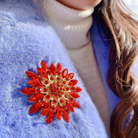Large red crystal brooch on lapel of woman's coat