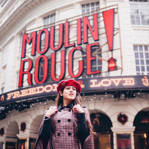 Red beret worn by woman posing in front of a theatre