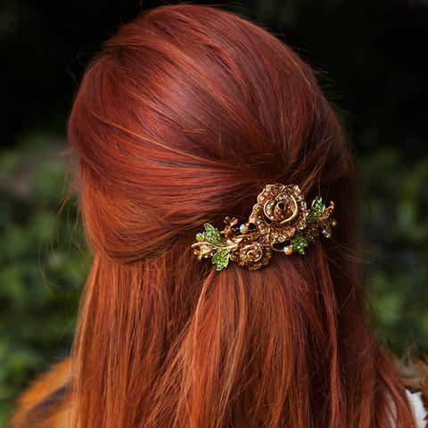 back of red haired woman with a brown rose clip in her hair