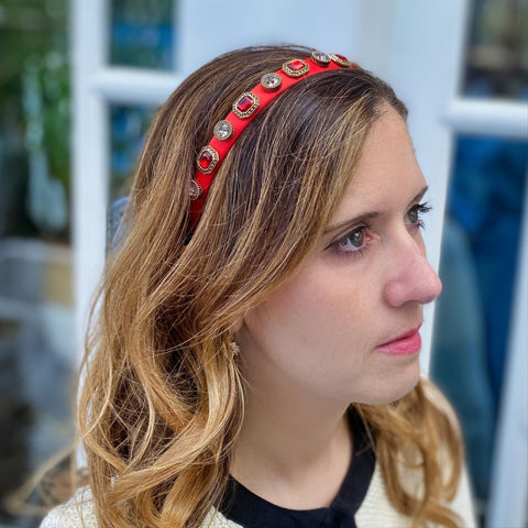 woman wearing red jewelled headband looking into the distance