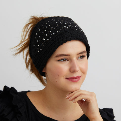 woman smiling wearing black winter ear warmer headband with diamantes on it and hair in a ponytail