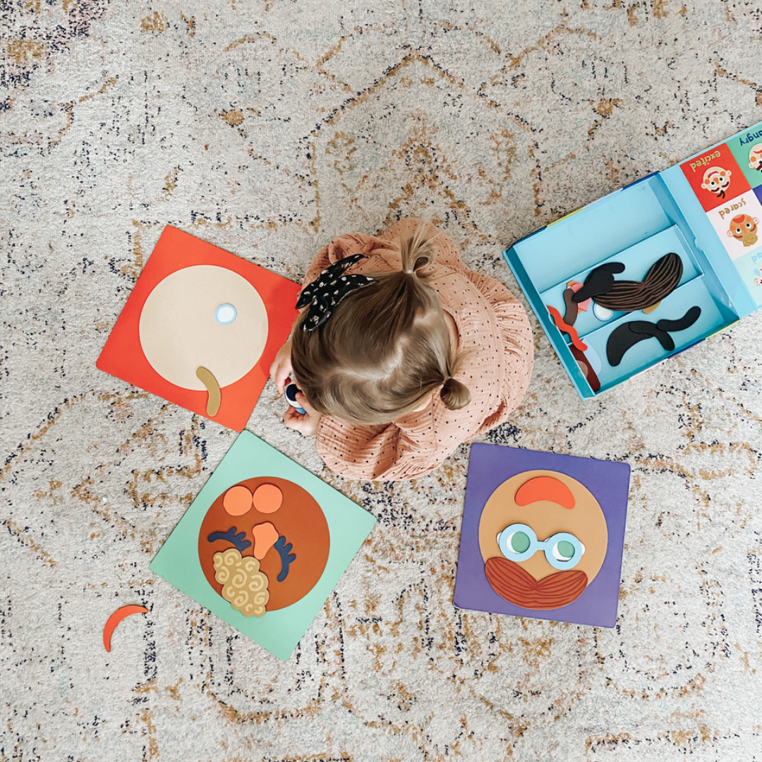 Girl playing with Making Faces Magnetic Set.