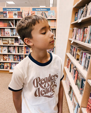 little boy wearing a "readers are leaders" shirt