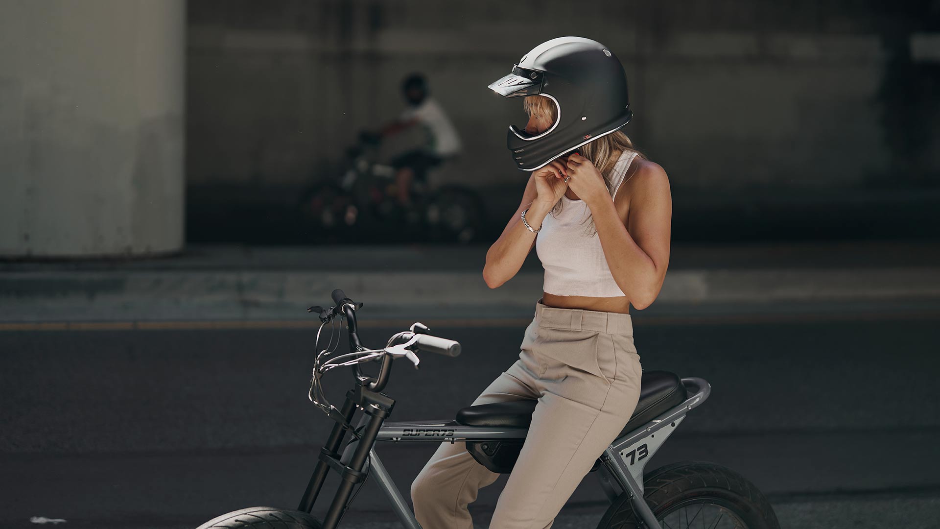 Rider fastening a helment sitting onSuper73 ZX ebike