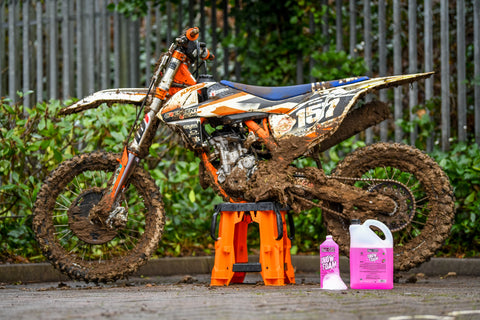 Dirty motocross bike with snow foam in foreground