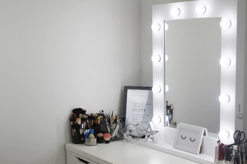 white gloss hollywood mirror with lightbulbs switched on