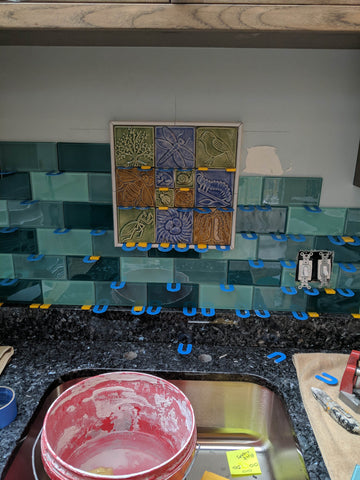 handmade tiles being installed over a sink