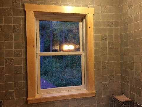 window surrounded by handmade tiles in bathroom