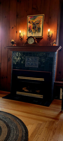 a fireplace featuring blue handmade tiles depicting the wildlife of montana