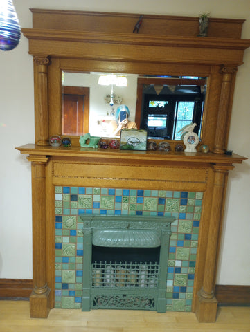 handmade tile hearth featuring green and blue tiles and a wooden mantle
