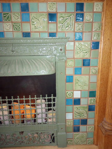 blue and green handmade tile hearth featuring plant and animal designs