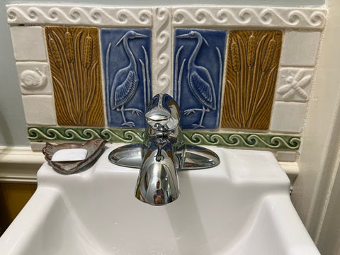 heron and cattail handmade tiles installed over a bathroom sink