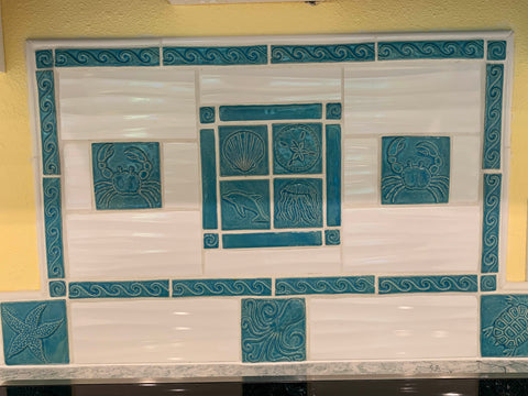 blue handmade tiles depicting sea creatures installed over a kitchen stove
