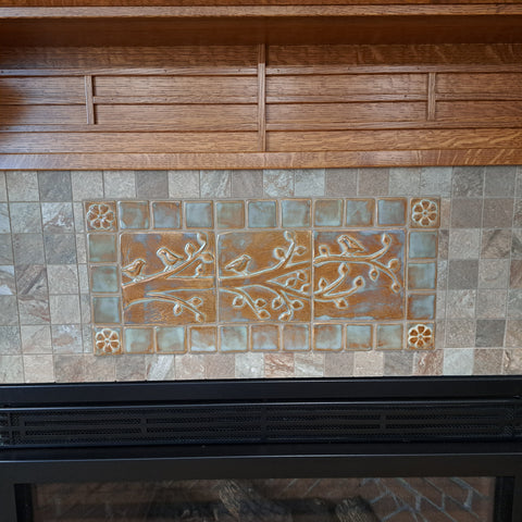 birds on a branch handmade tiles by Emu Tile installed over a fireplace