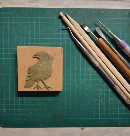 sculpting a crow handmade tile