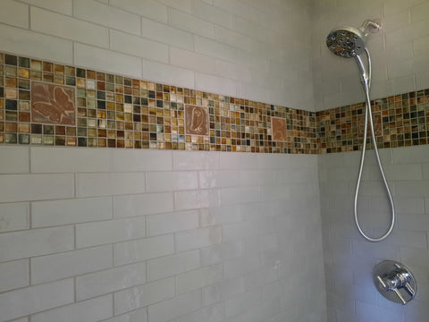 tiled shower with a stripe of handmade tiles mixed with glass tiles