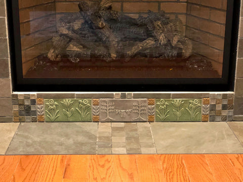 handmade tiles installed below a fireplace insert