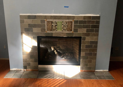 installing handmade tiles around a fireplace 