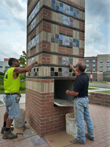 masons at work installing handmade tiles in the chimney swift tower in downtown kent ohio