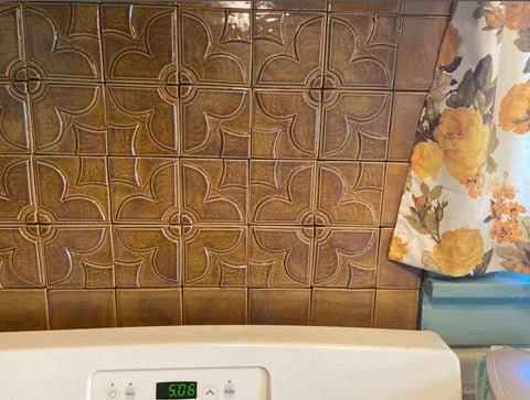 handmade quatrefoil tiles in honey glaze installed behind a stove in a kitchen