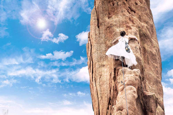 Woman in dress climbing a rock