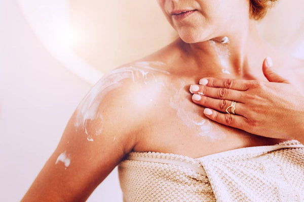 Woman putting on body cream