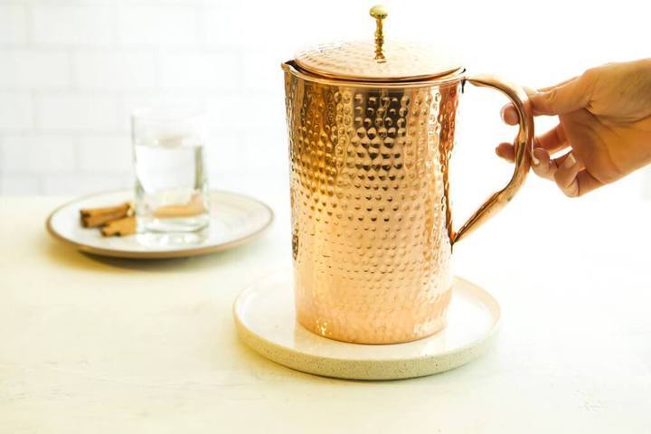 hand holding Shantiva copper pitcher handle placed on a coaster