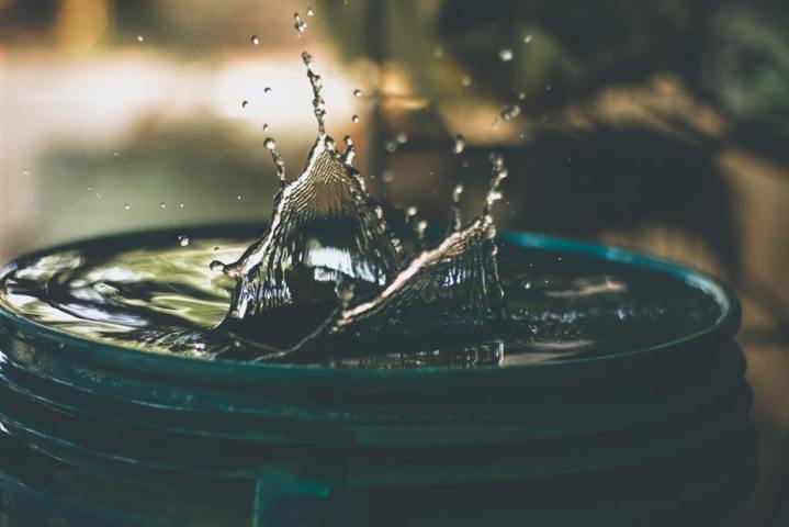 water drop on a full plastic blue bucket