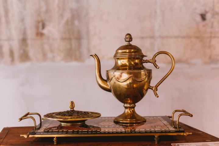 elaborate gold teapot placed on a tray