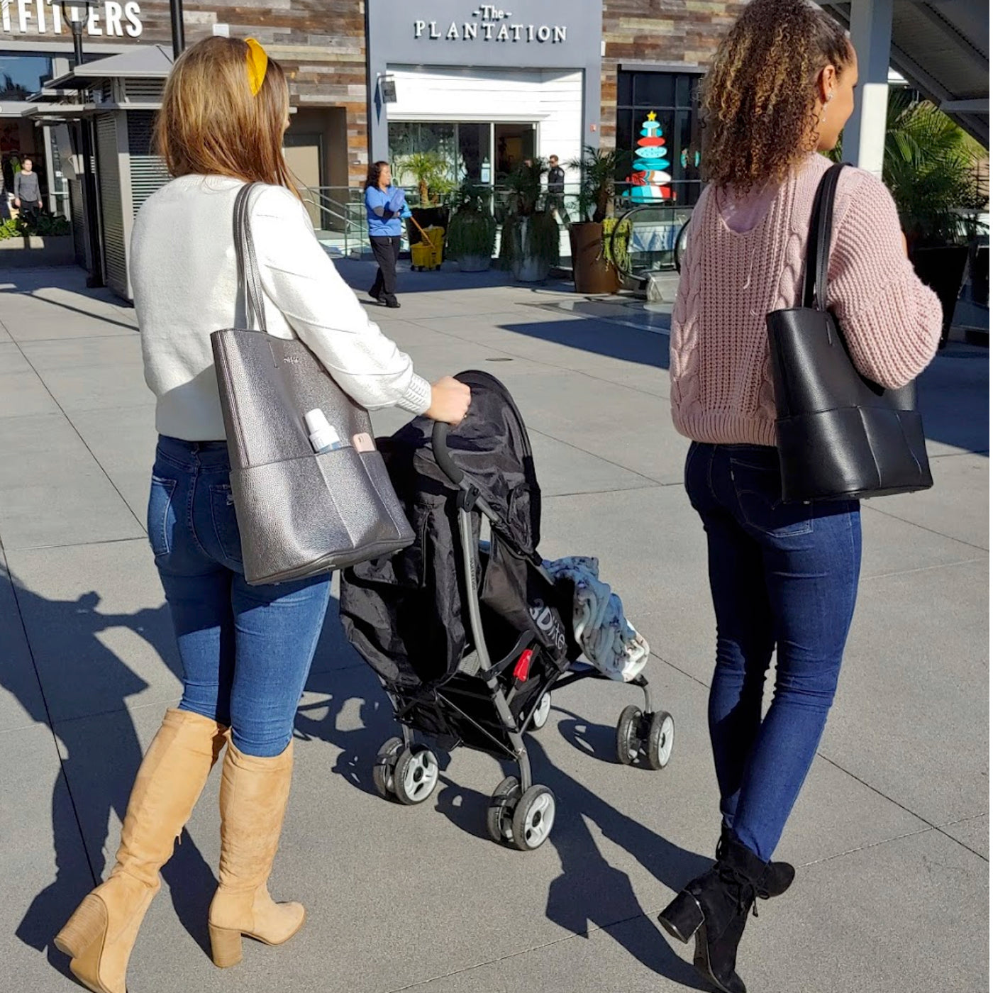 Walking with the baby in stroller. Hannah is carrying the Pewter Tote and keeping the baby's bottle warm and her cell in the insulated pockets. Renee has her favorite Black Midi Tote.  @PacificCity