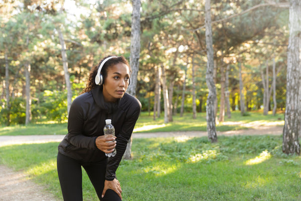woman drinking water bottle for outdoor exercise