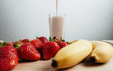 Fruit smoothie fresh blended on wood table.