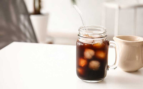 Mason jar of tasty cold brew coffee protein shake on table.