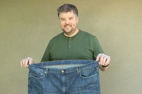 Man with jeans that are way too big for him because he lost weight.