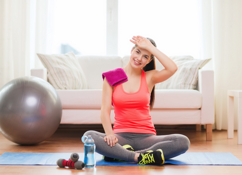 girl with bottle of water after exercising at home