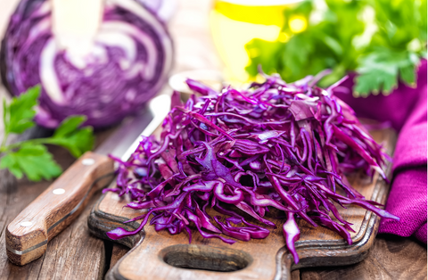 shredded red cabbage on wooden cutting board 