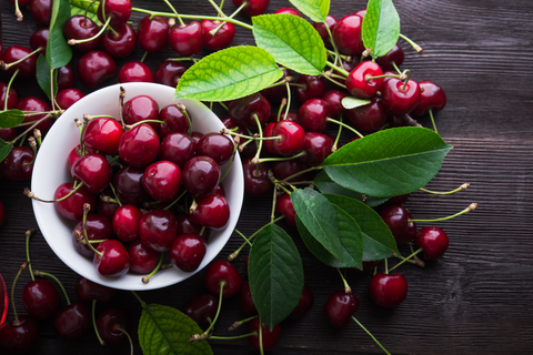 cherries in bowl on wooden table