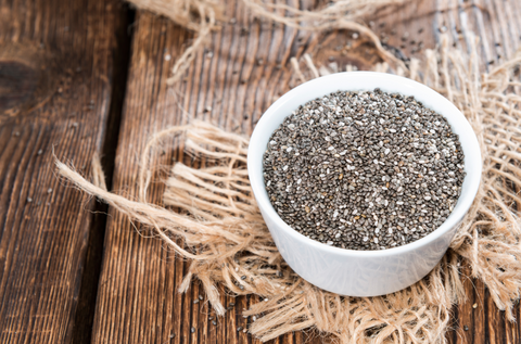 Chia Seeds in a small bowl (on dark wooden background)