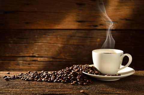Coffee cup and coffee beans on old wooden background