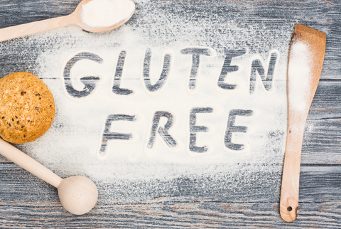 Gluten free word written on flour. Table wooden background.