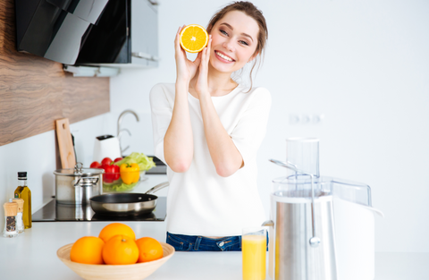 woman smiling juicing oranges