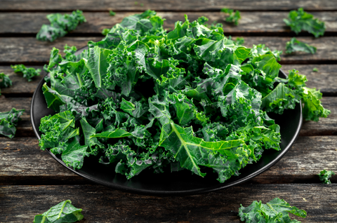  kale leaves in a black plate on wooden rustic table
