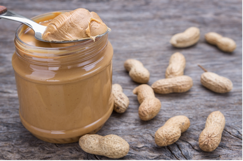 jar of peanut butter on wooden background